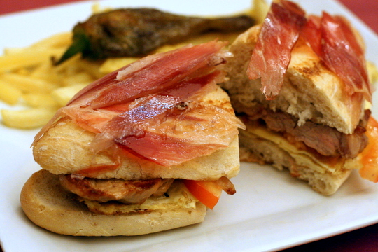 The classic seranito sandwich, seen here filled with egg and tomato, as well as ham and pork, is a local favorite and most definitely one of the most epic sandwiches in Seville