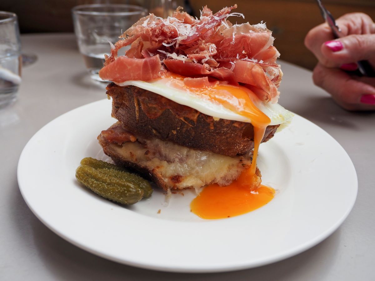 a french inspired croque monsieur topped with ham.
