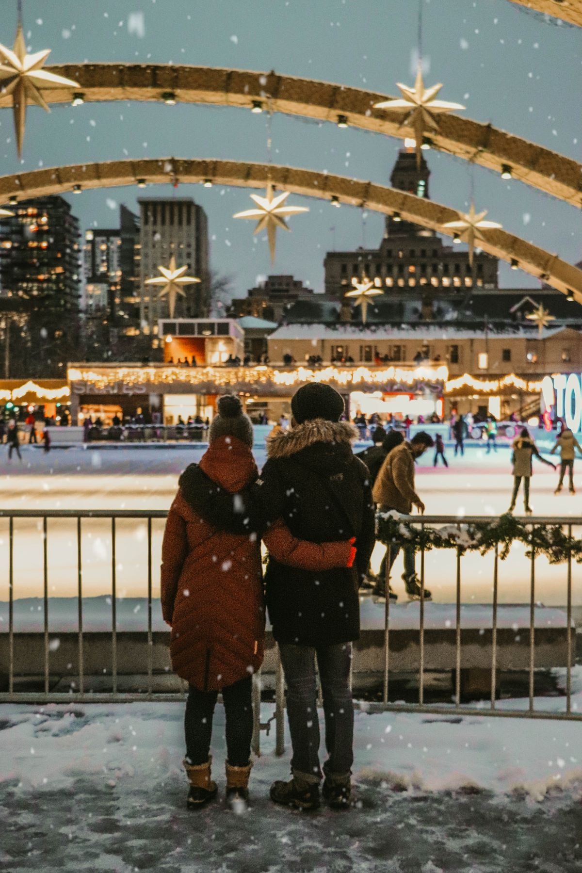 A couple watching people ice skating 