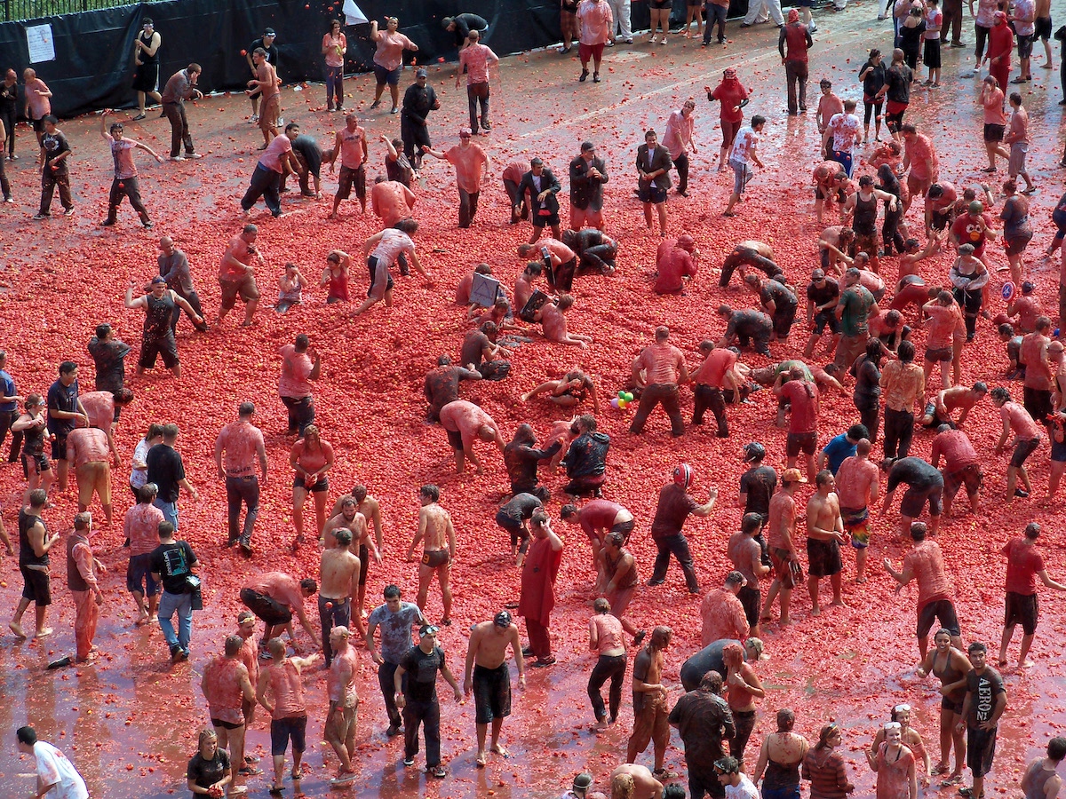 Large group of people throwing tomatoes at each other during the La Tomatina festival in Spain.
