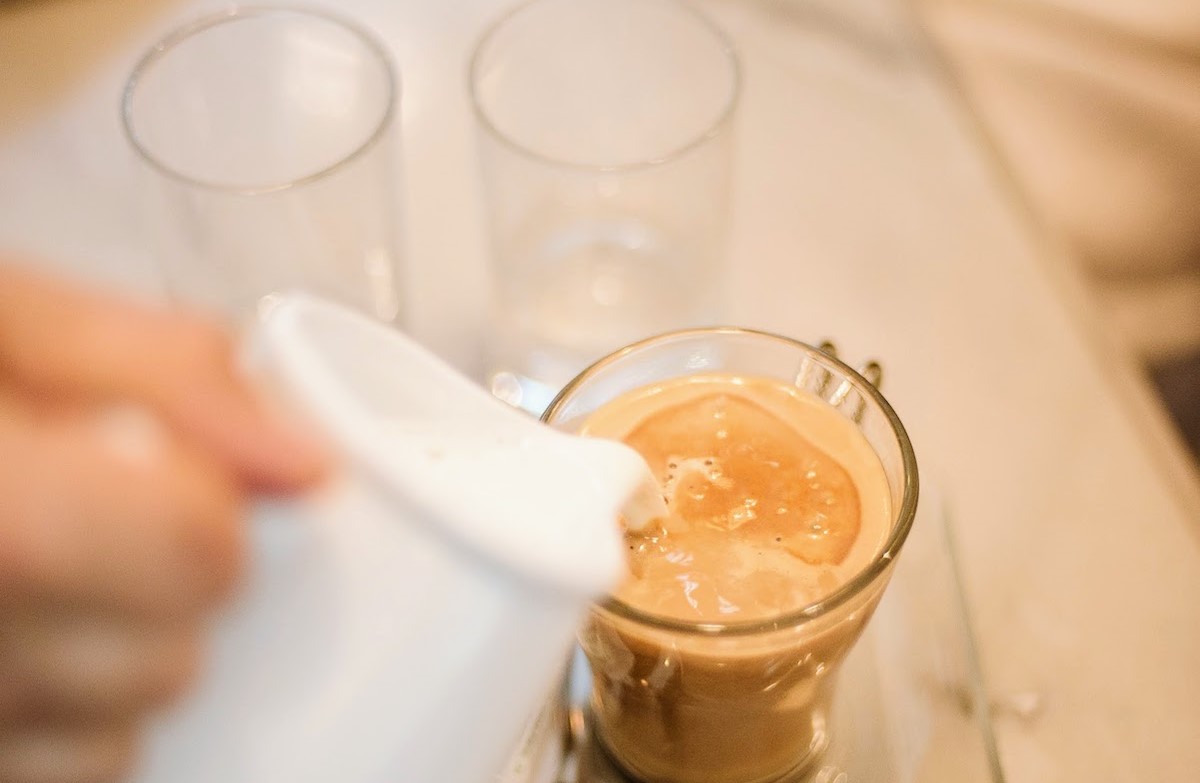 milk being poured into coffee