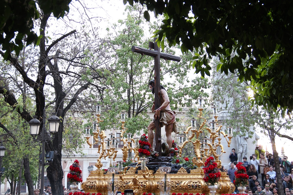 View of a Easter procession in Seville through the trees