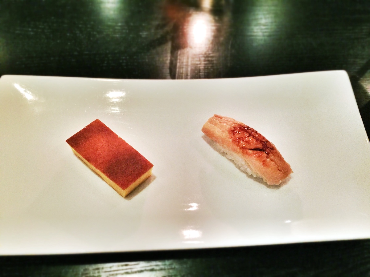 Two pieces of sushi on a white rectangular plate