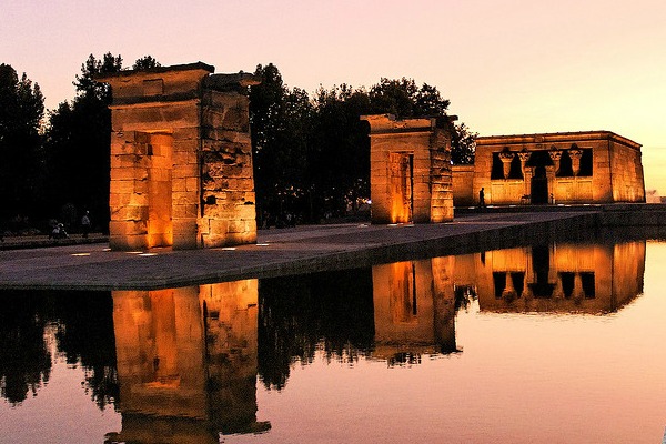 The gentle colouring o a sunset at Templo de Debod, with the building beautifully reflected in the surrounding water is a great date idea for warm weather in Madrid 