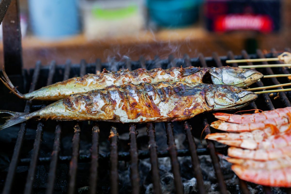 Fish being cooked over an open flame. 