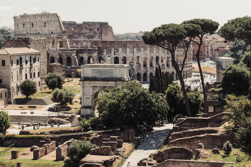 Colosseum and Roman Forum in the daytime with trees and plants