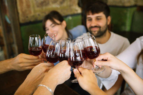 People cheering glasses of red wine