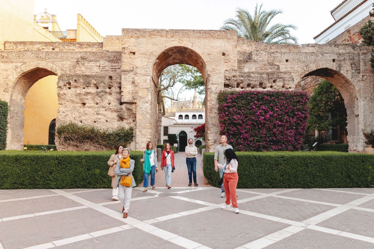 A guide leads a group on a tour at the Alcazar in Seville