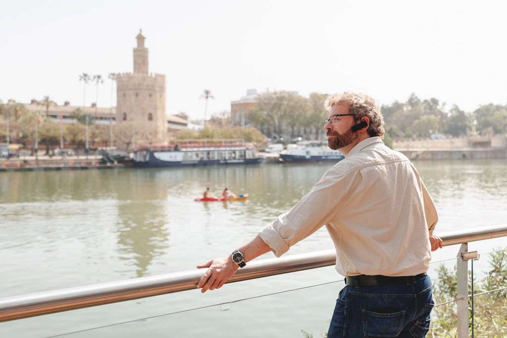 Visitor listens to a tour about Seville while overlooking the Guadaliquivir River in Triana, Seville