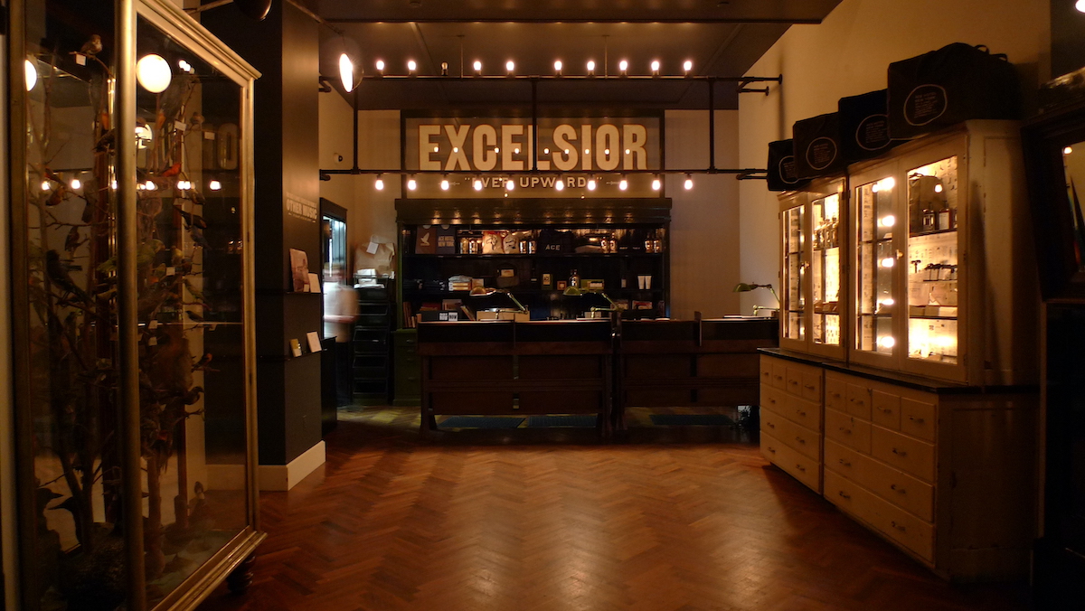 Shopping counter in a dimly lit hotel lobby with the word Excelsior above it on the back wall