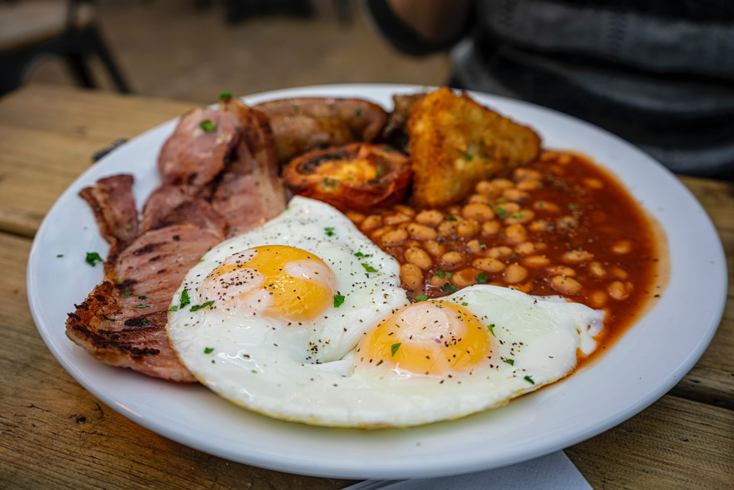 Full english breakfast with fired eggs, bacon, beans, and tomatpoes