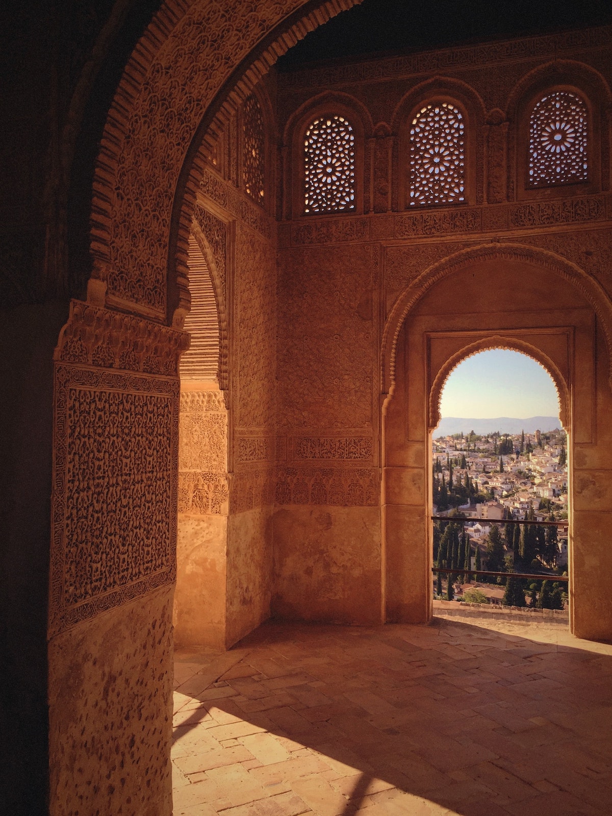 Moorish-style architecture featuring an arched window with a city visible in the distance