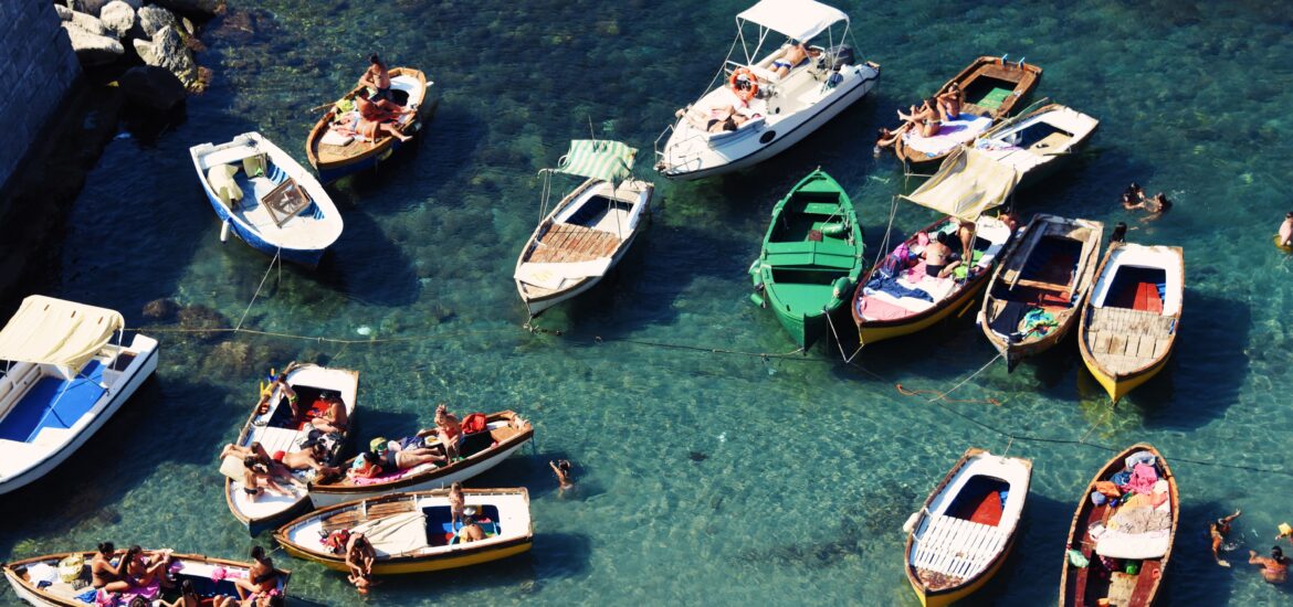 Colorful boats floating in a crystal clear sea on a sunny day