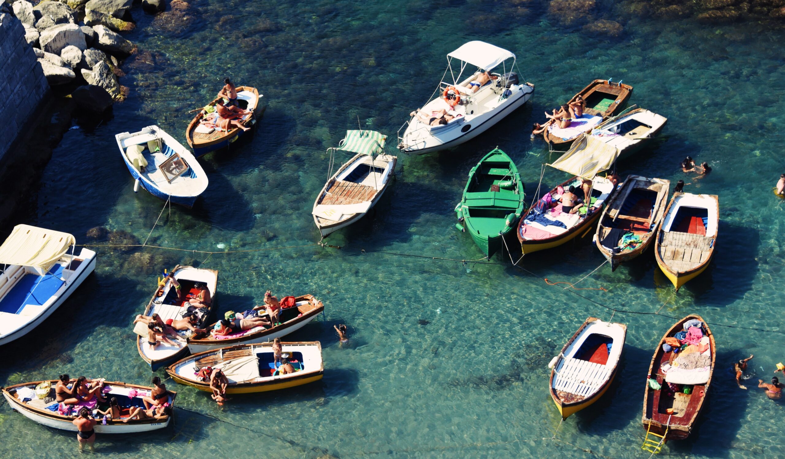 Colorful boats floating in a crystal clear sea on a sunny day