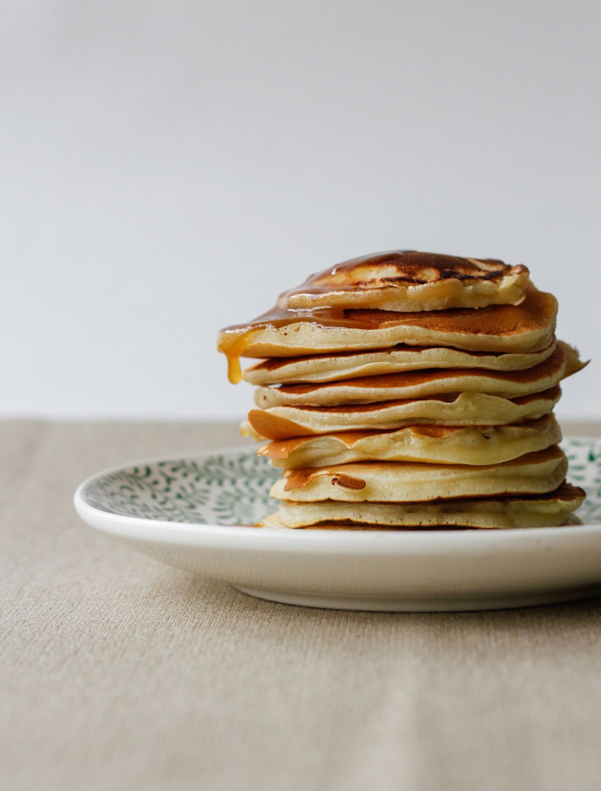 A plate stacked high with pancakes.
