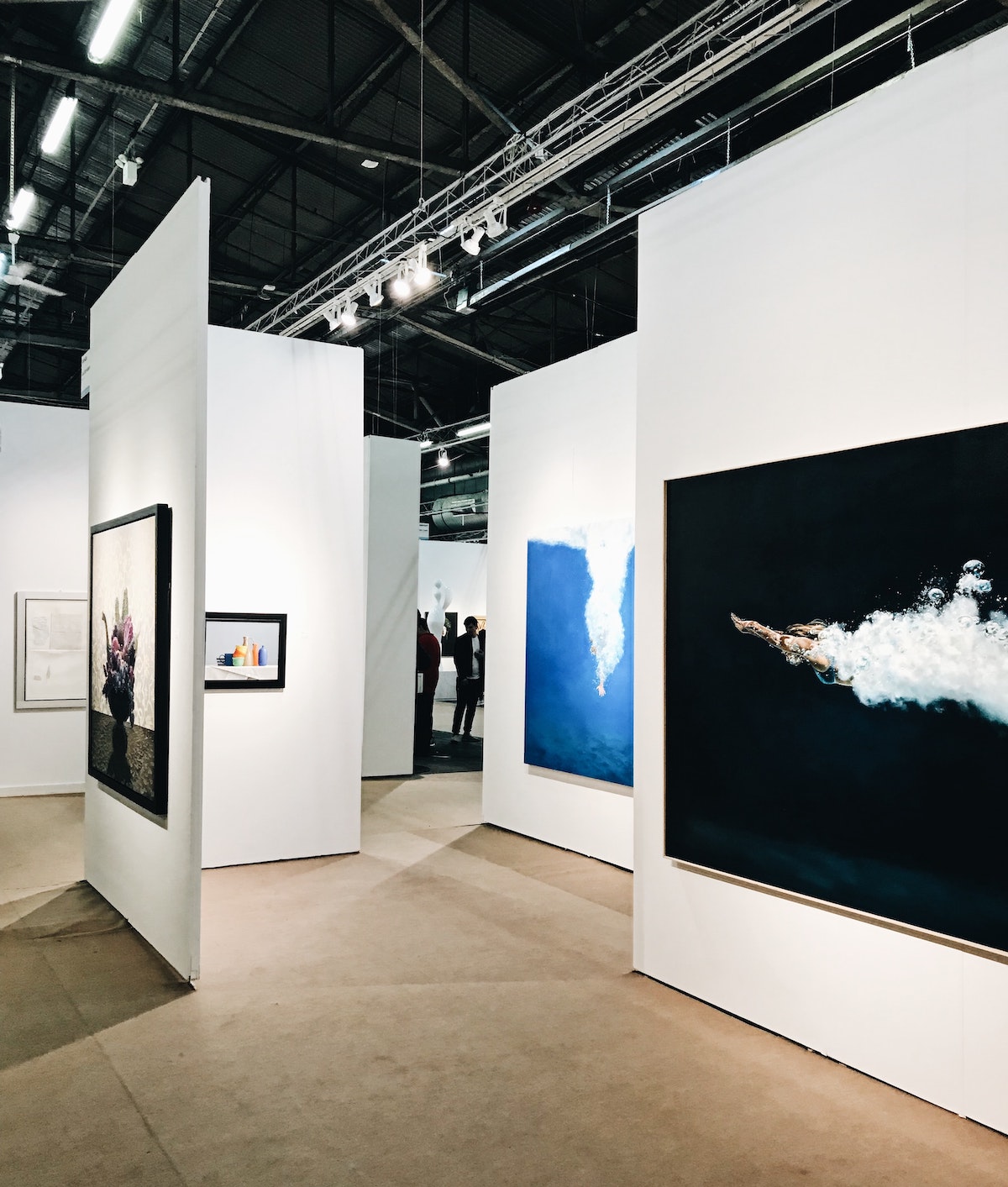 Large photographs displayed on white art gallery walls.