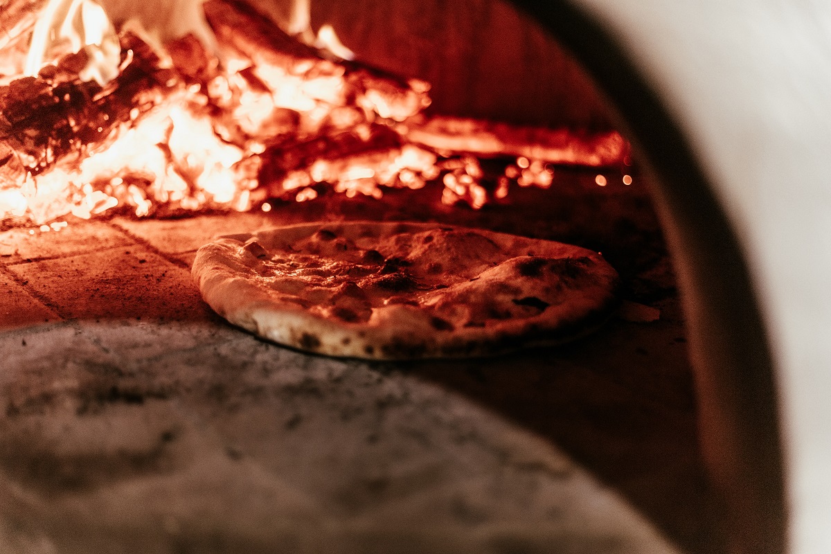Pizza baking in a wood-fired pizza oven
