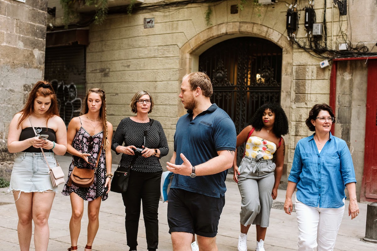 Six people chatting and walking around a city.