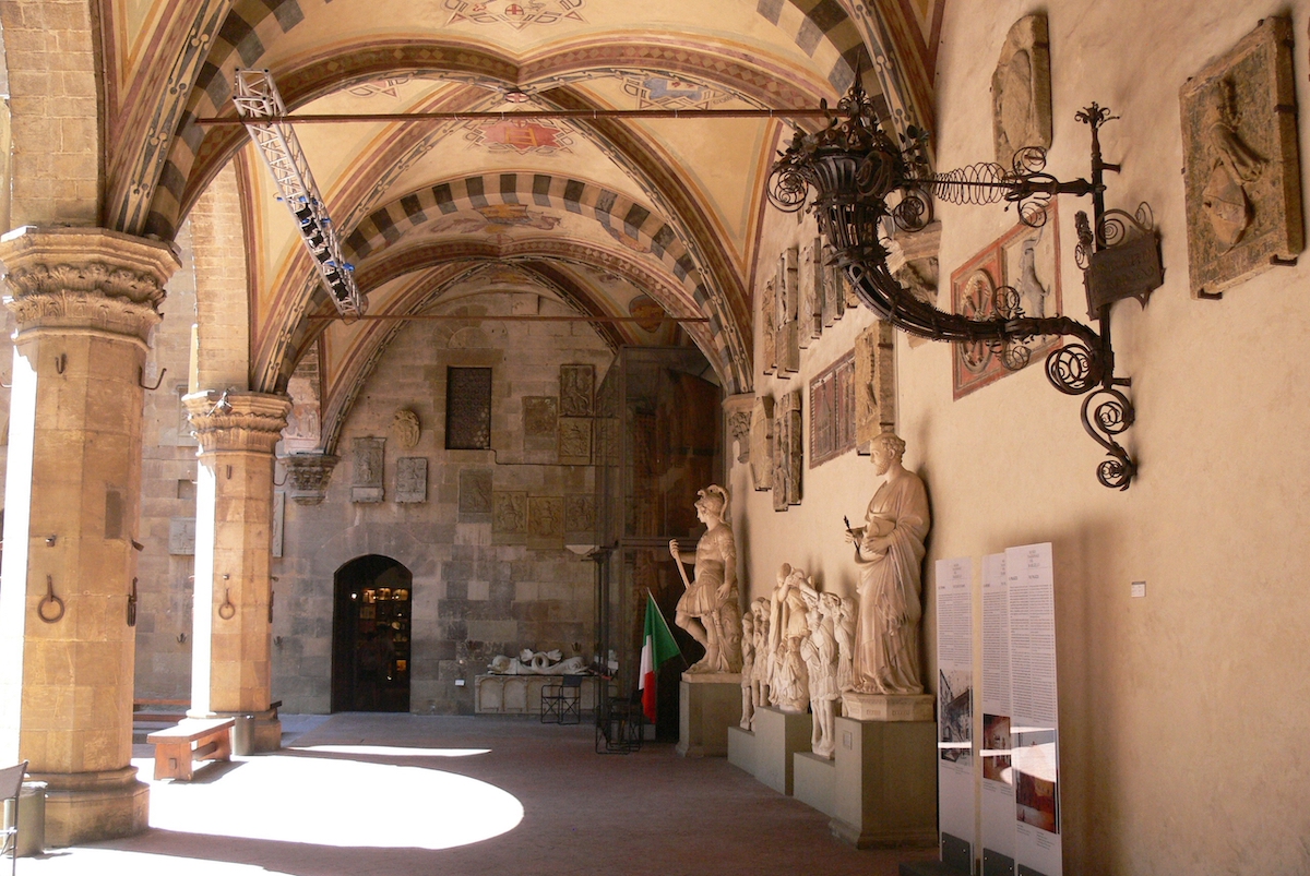 Inner courtyard of the Bargello Museum in Florence with high ceilings and marble statues