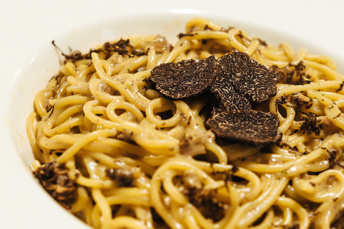 Long pasta noodles garnished with black truffles