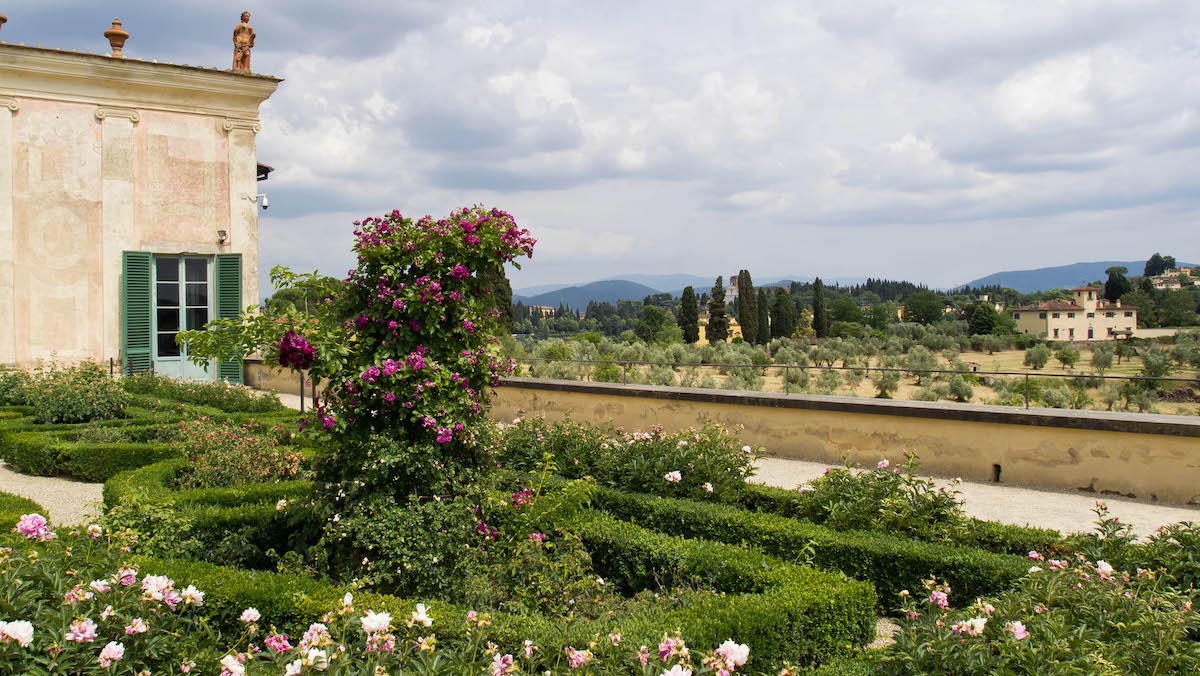 Gardens at an Italian villa with a small brown building in the background
