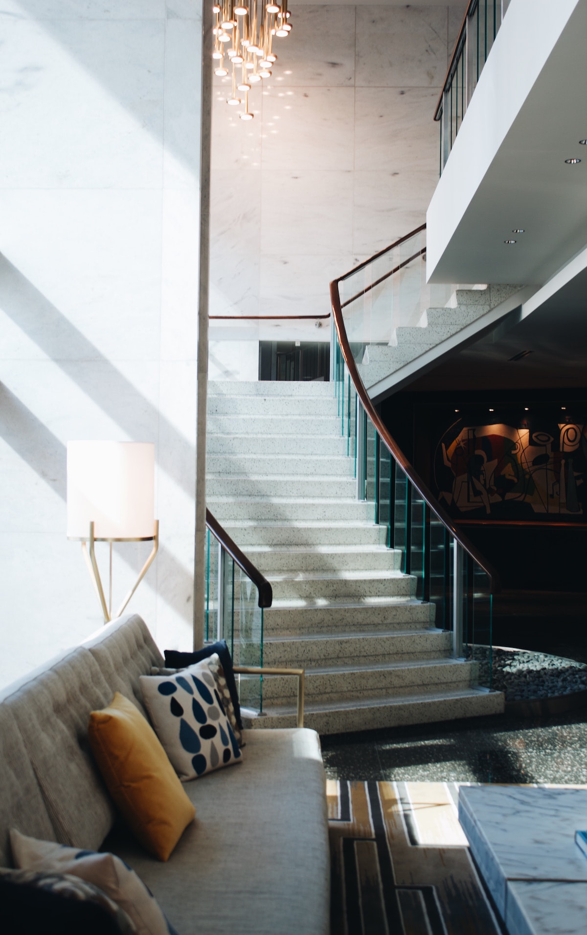 Lobby of a boutique hotel decorated in neutral tones with a stone staircase leading in
