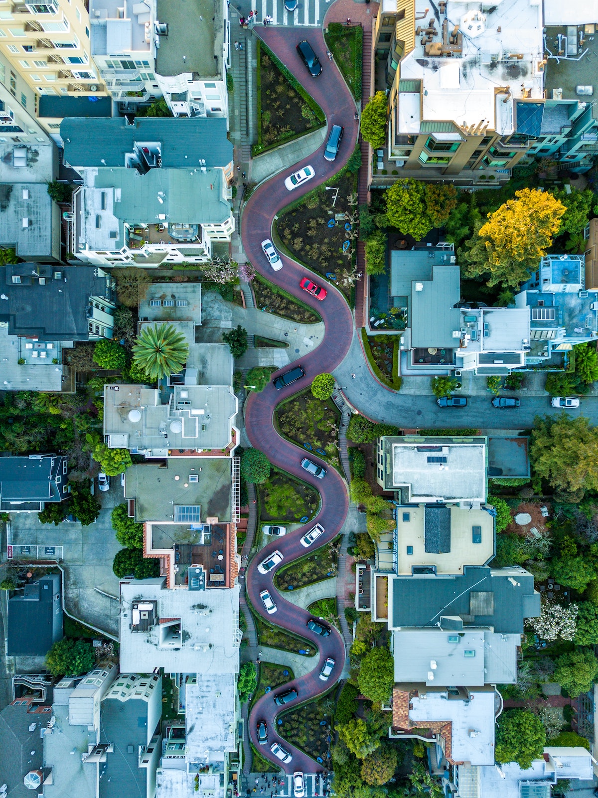 An aerial view of cars driving down the snaking Lombard street in San Francisco with eight hairpin turns