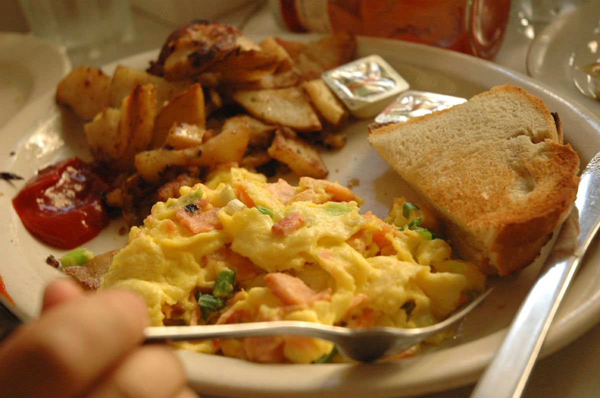 Salmon omelet on a plate with toast and hash browns