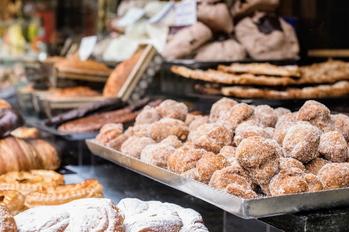 Close up of fried donut balls dusted with sugar on display at a bakery