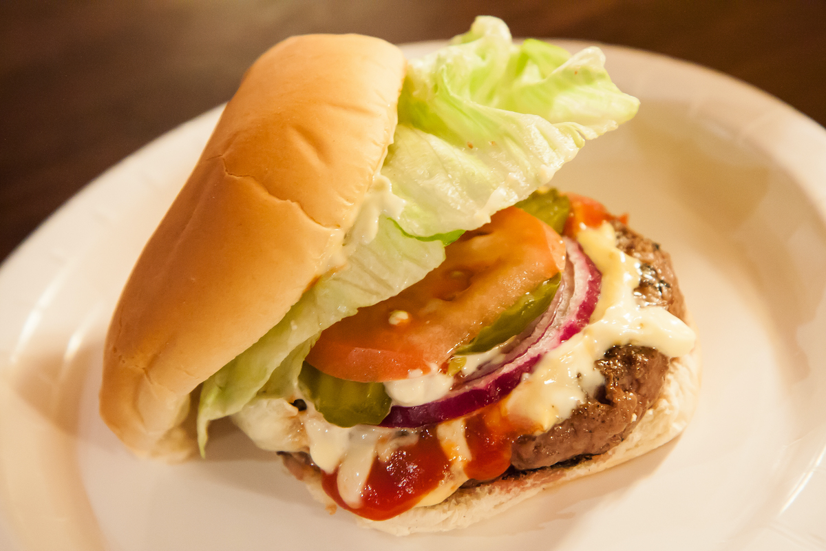 Hamburger with lettuce, tomato, onion, pickles, and cheese