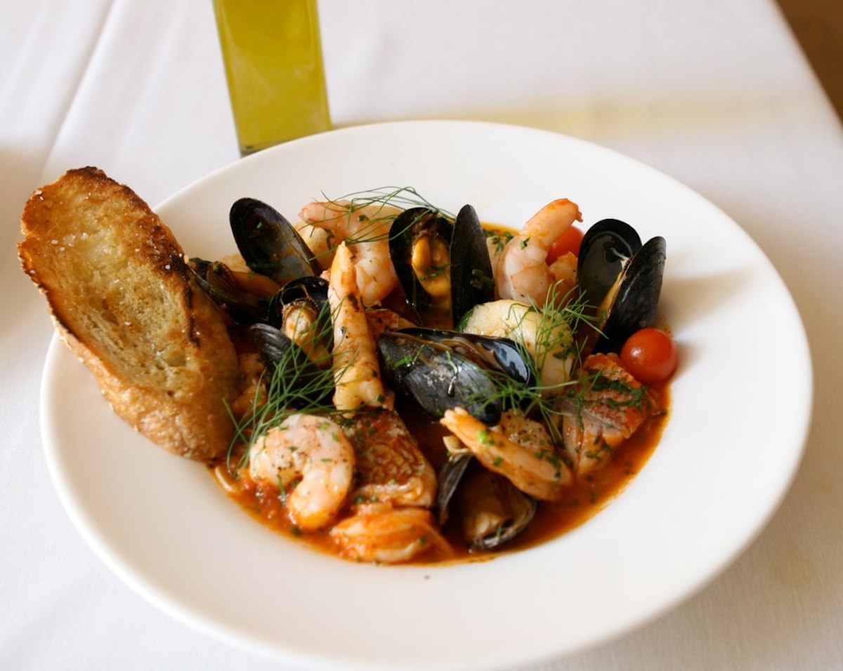 Seafood stew with shrimp, mussels, and fish in a tomato broth sprinkled with fresh herbs