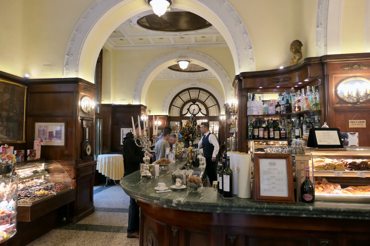 Interior of a historical cafe in Florence, Italy, with high arched doorways and dark wood paneling