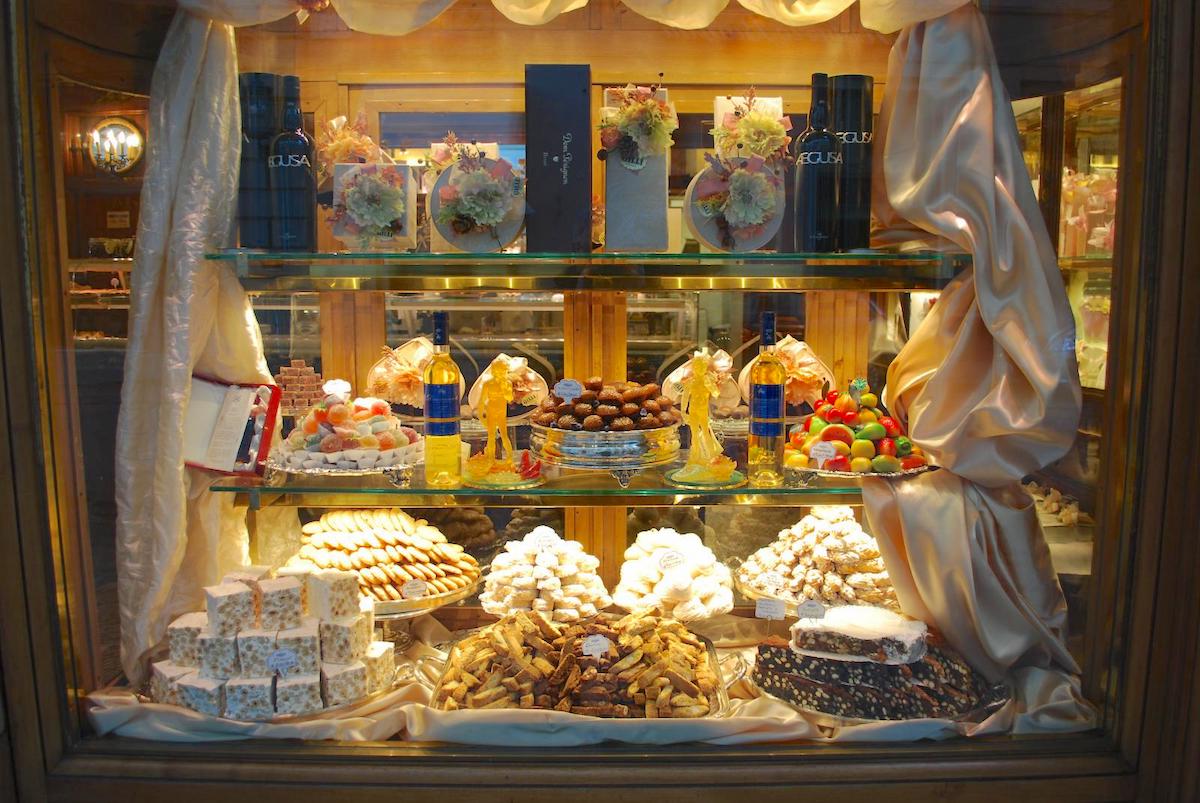 Pastries and candy on display in a bakery window.