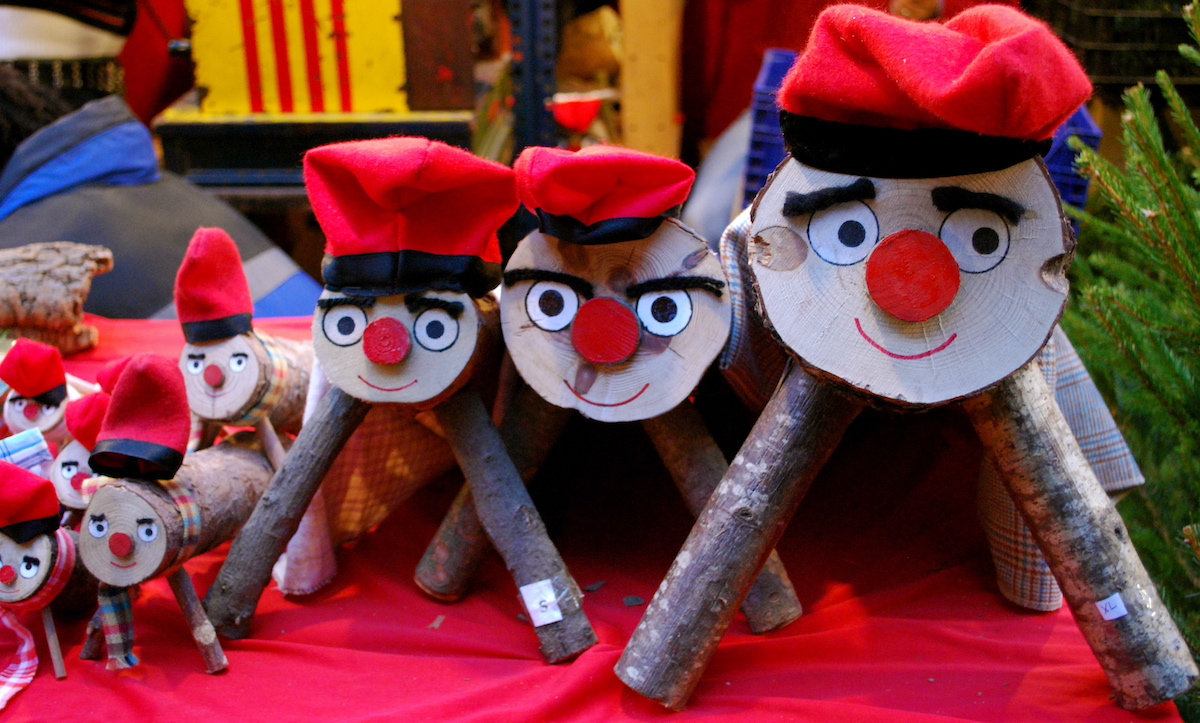 Wooden logs decorated with faces and holiday hats