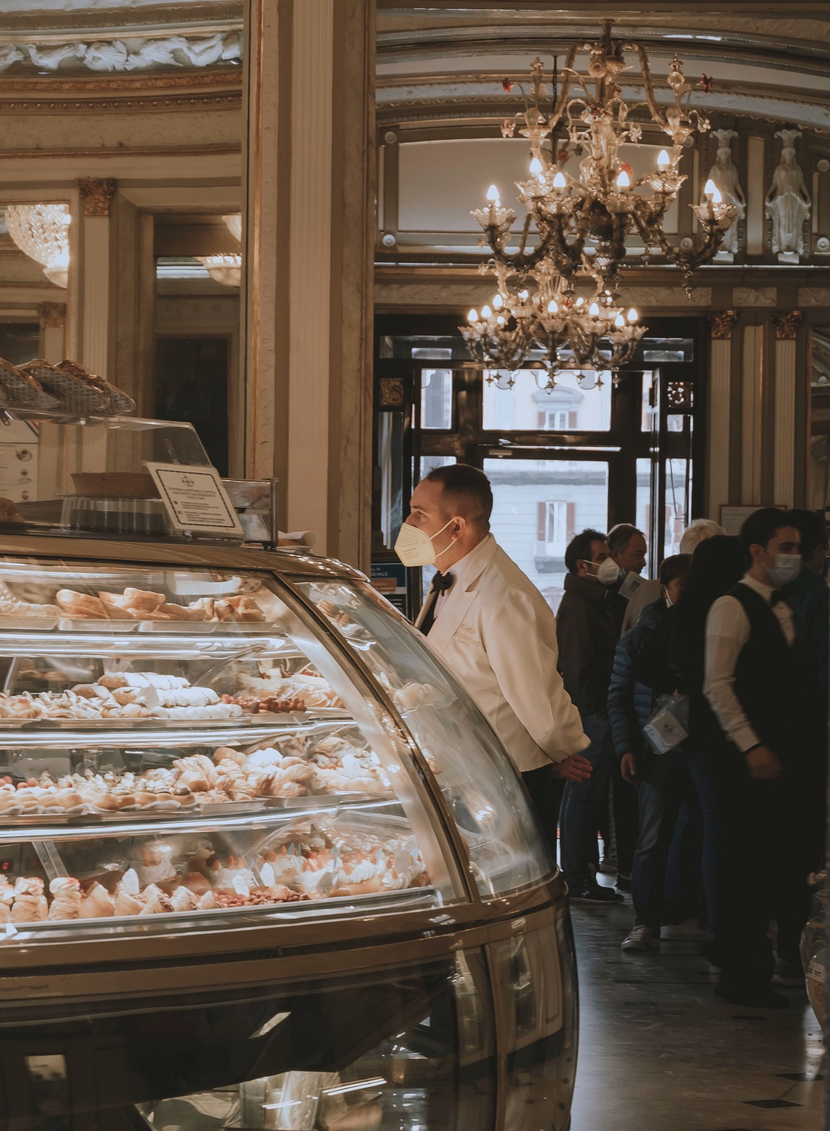 Bakery counter with pastry and waiter in Naples