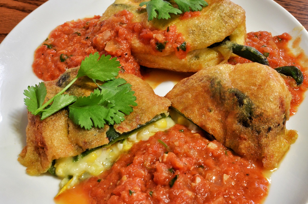 Chiles rellenos served with Mexican salsa and fresh cilantro