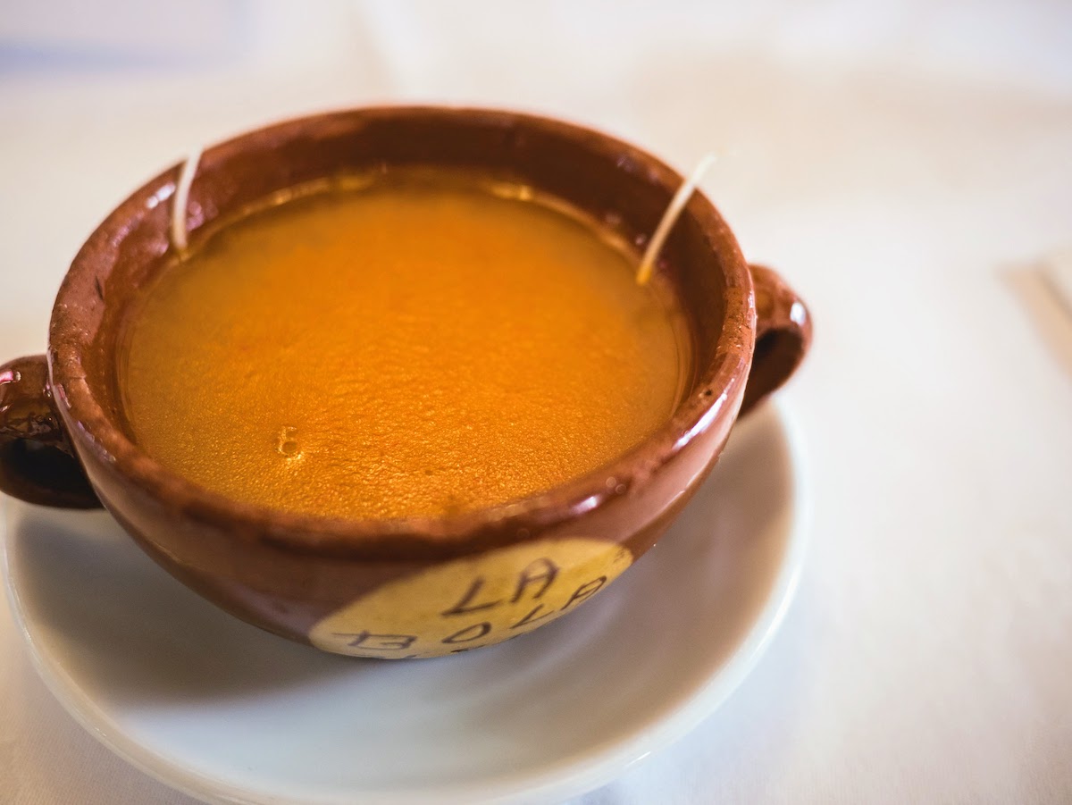 Overhead shot of brown broth in a small terra cotta bowl