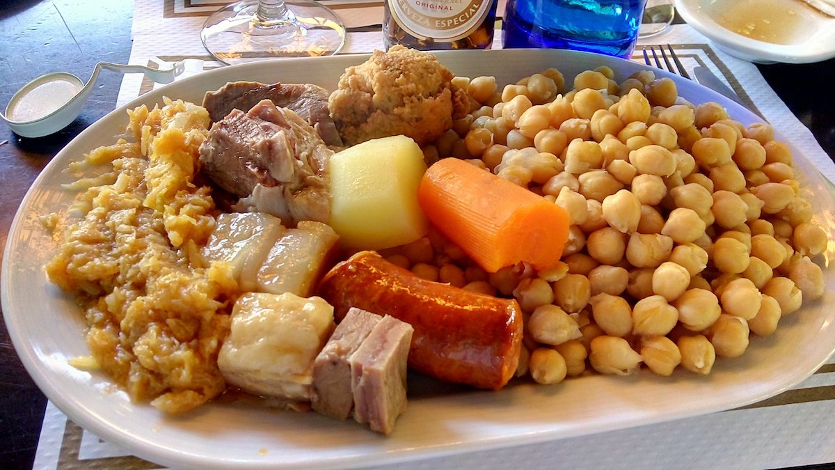 Large plate full of chickpeas, meats, and vegetables