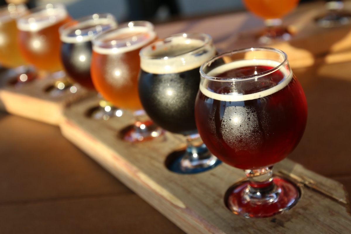 Flight of dark-colored beers on a wooden board