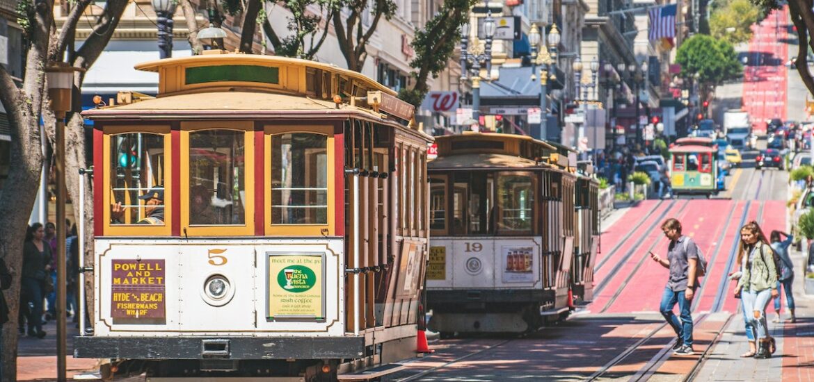 A line of cable cars on the street. The cable car turnabout is a great stop on your San Francisco city tour.