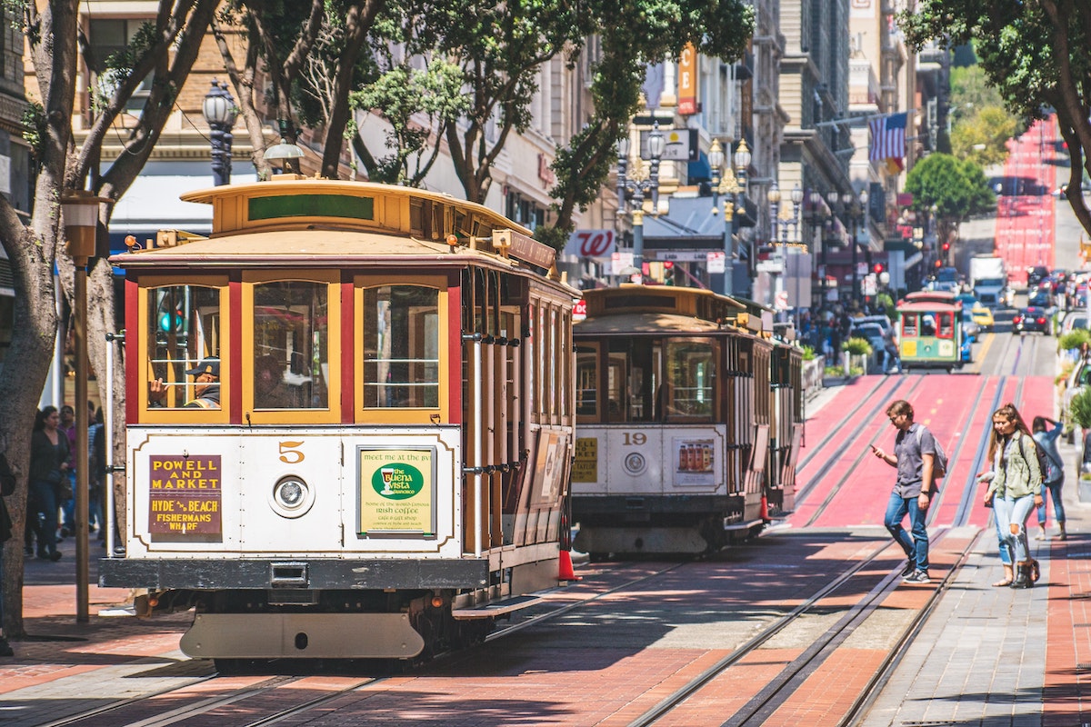 A line of cable cars on the street. The cable car turnabout is a great stop on your San Francisco city tour.