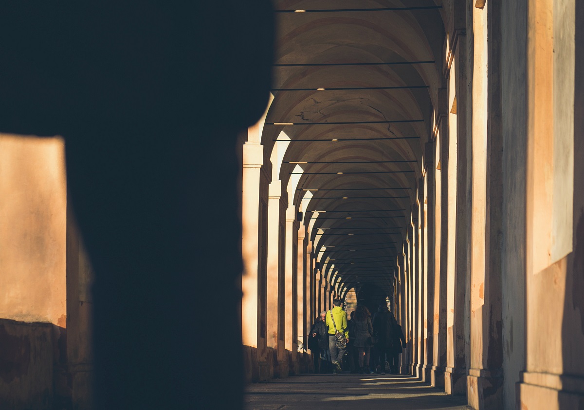 Couple walking under porticoes in Bologna, Italy