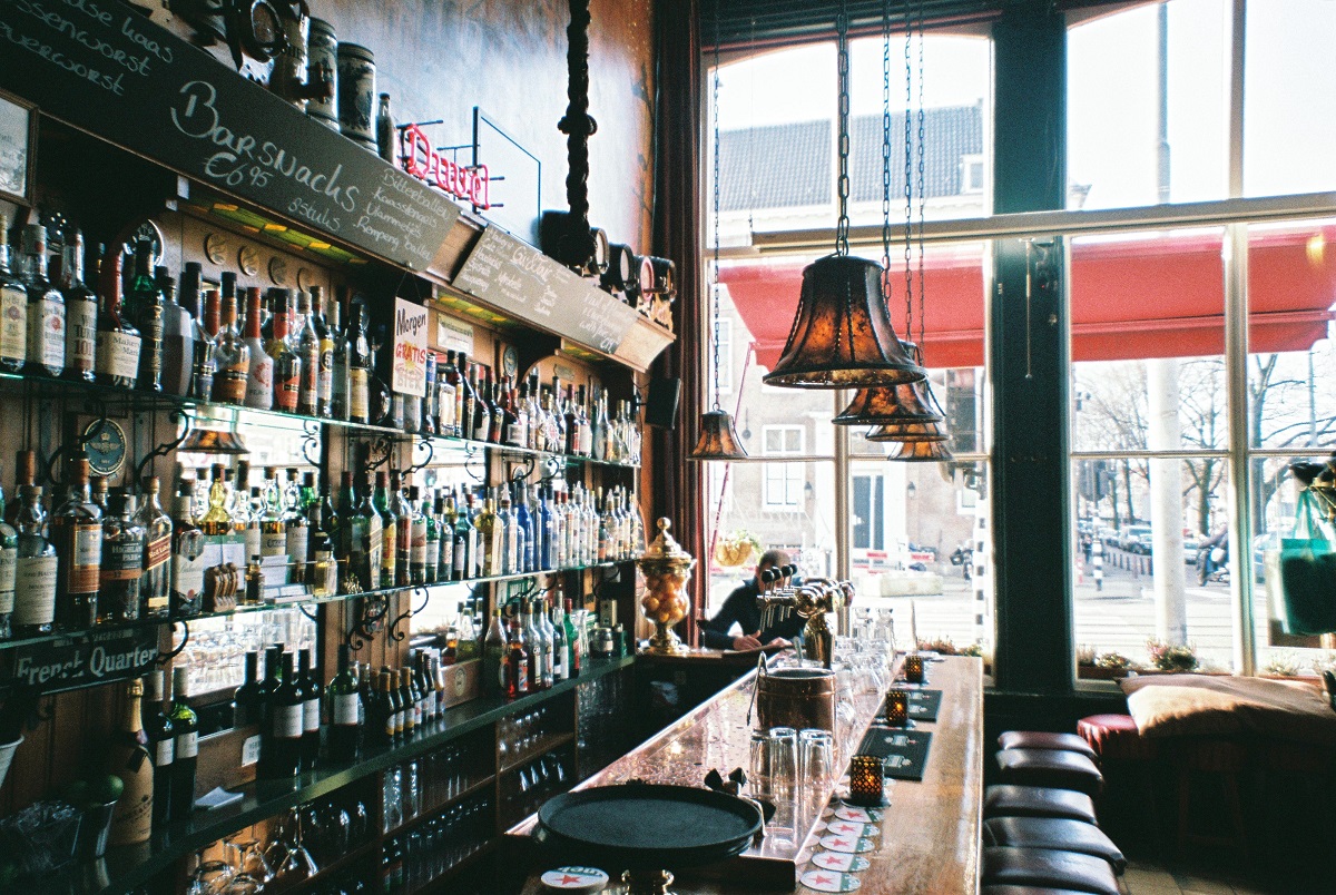 Interior of a bar in Amsterdam with many beer bottles and cocktail glasses