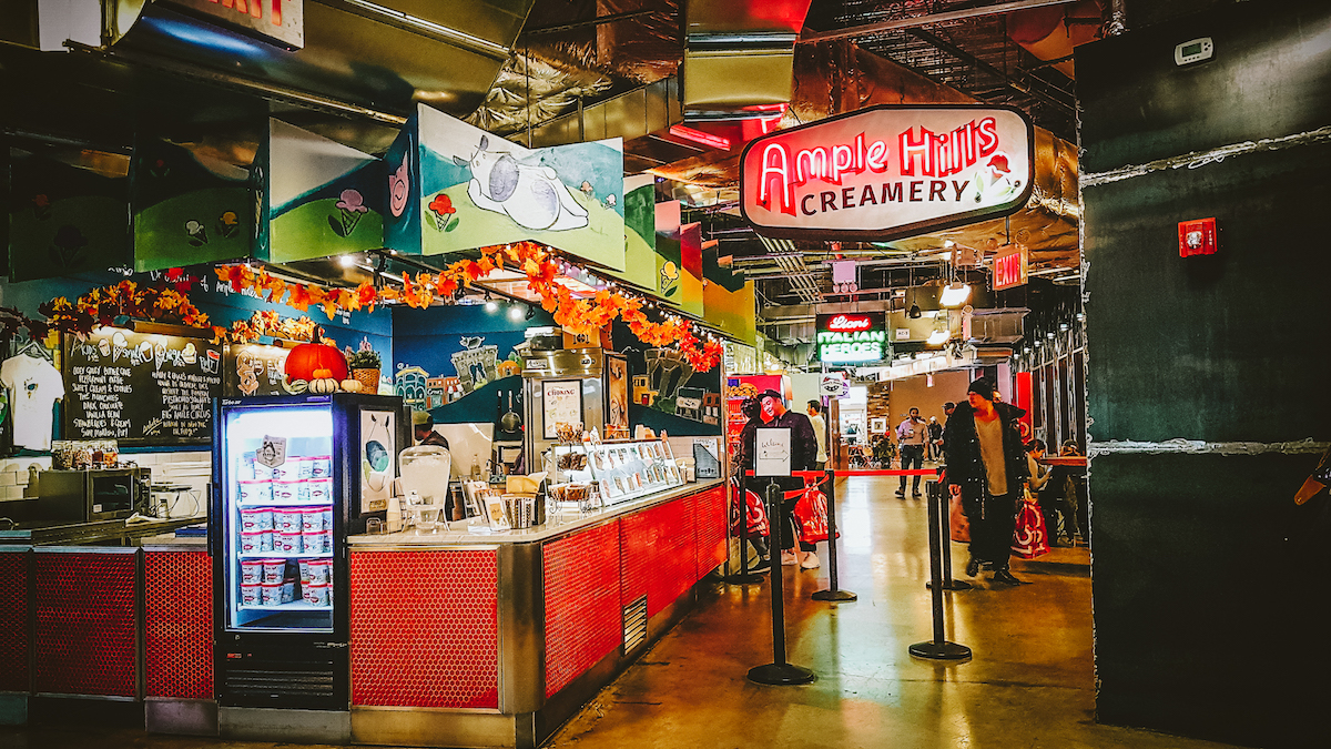 Colorfully decorated food stalls in an indoor market space.