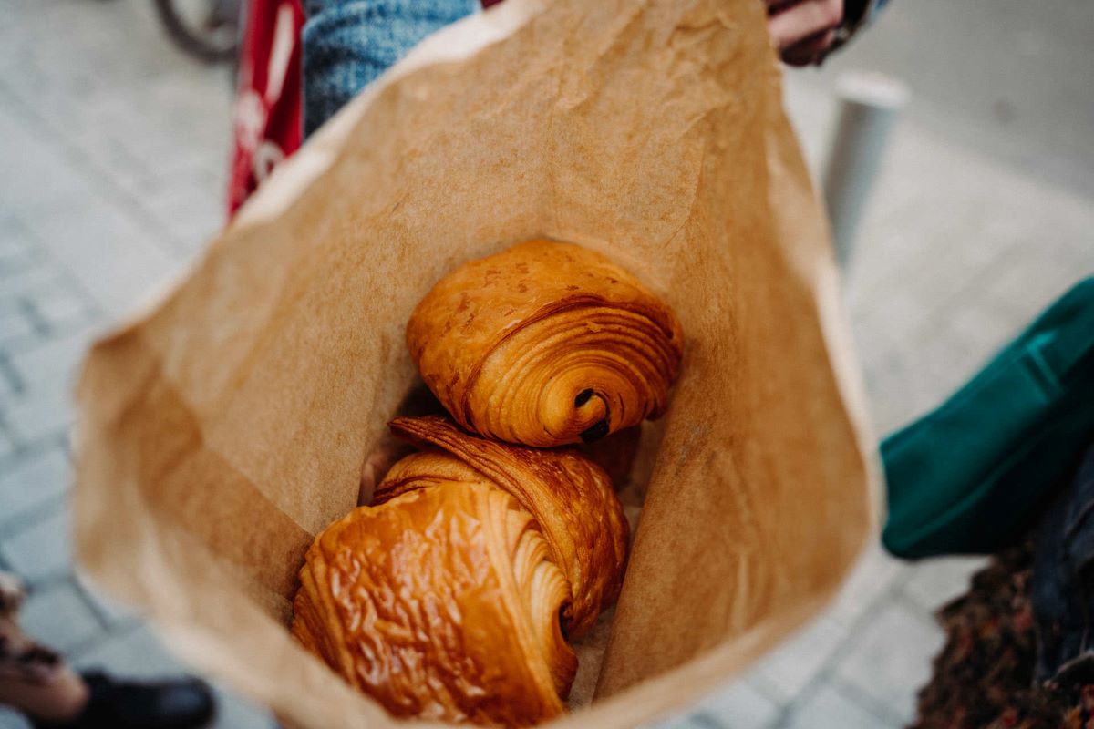 A bag containing two French pastries known as chocolatines.