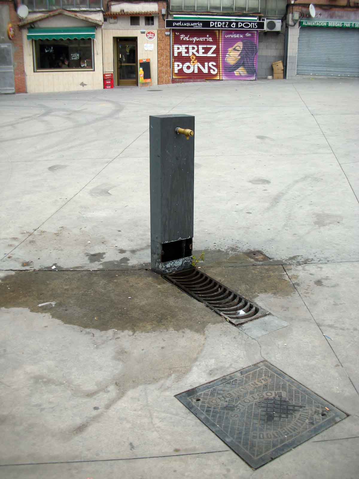 Rectangular stone drinking fountain on the sidewalk