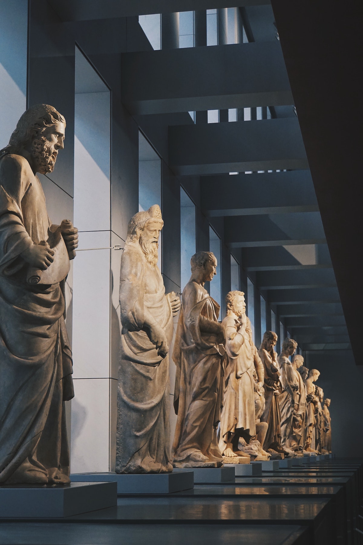 White stone statues of men inside a museum