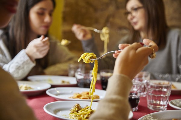 Group of people eating pasta