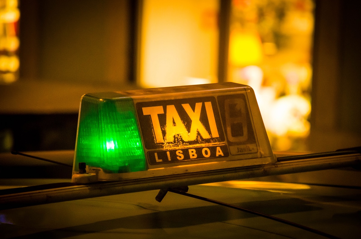Lisbon taxi with Lisboa sign and green light on a night