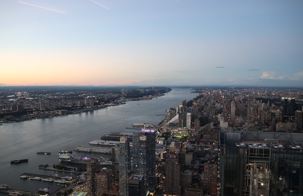 View of New York City and the river as seen from above at dusk.